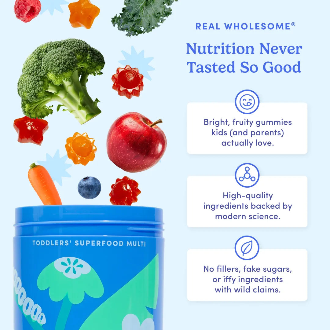 A blue tub labeled 'TODDLERS' SUPERFOOD MULTI' with floating fruit and vegetable illustrations and marketing text on a light blue background. Visible text includes 'REAL WHOLESOME Nutrition Never Tasted So Good' and product claims about bright, fruity gummies and high-quality ingredients.